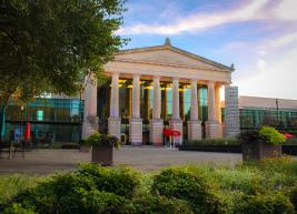 The entryway of Raleigh Memorial Auditorium highlights the gothic columns during a sunset.