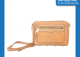 an image of a tan crossbody bag sitting on a table 