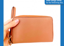 an image of a hand holding a tan wallet